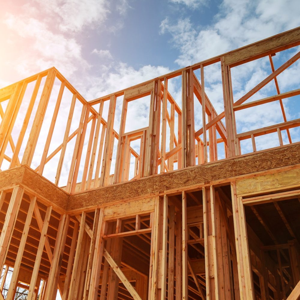 New residential construction home framing against a blue sky